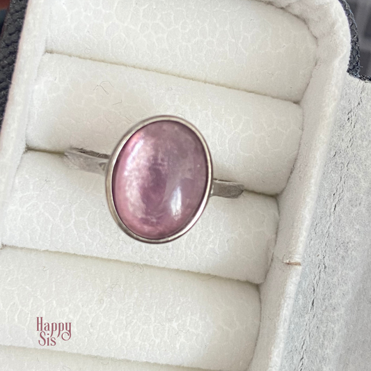 925 sterling zilveren ring met een ovale paarse mica steen in een gladde bezelzetting. De lila steen heeft een zachte natuurlijke glans en is geplaatst op een fijne, verstelbare zilveren ringband. purple mica sterling silver ring